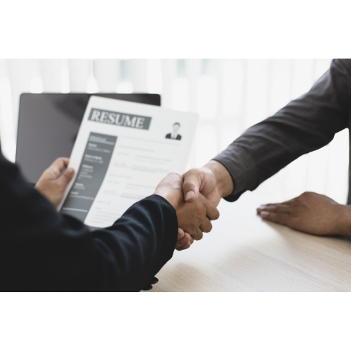 Two people shaking hands over a resume