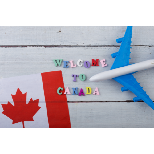 Image of Canadian flag and toy airplane with wooden letters reading "Welcome to Canada"