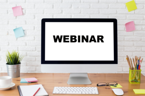 Computer on desk with the word "webinar" written across it