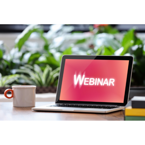 Laptop displaying the word "webinar" with coffee cup next to it