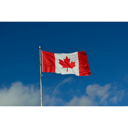 Canadian flag against blue sky with clouds