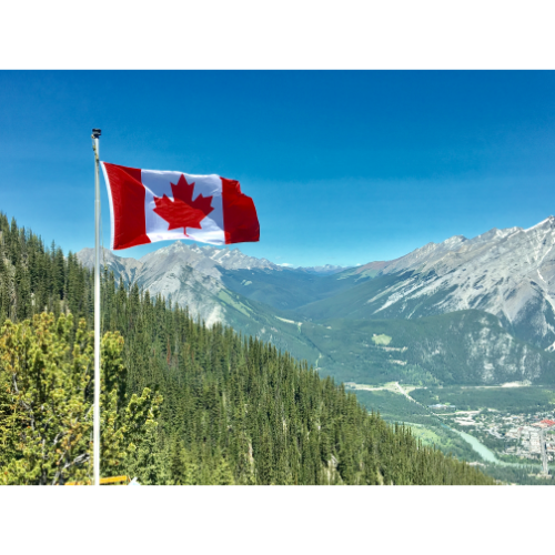 Canadian flag with mountain range view in background