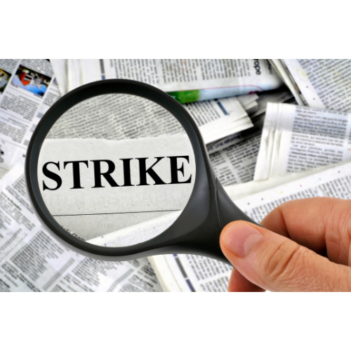 Magnifying glass over the word "strike" in newspaper