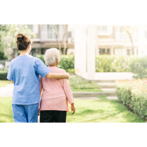 Caregiver walking with elderly person outdoors