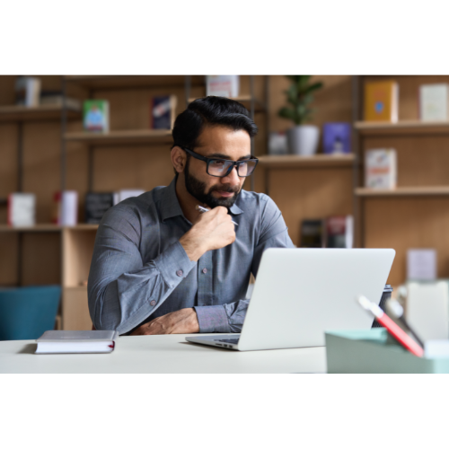 Person in front of a laptop with a bookcase behind them